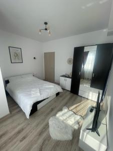 Habitación blanca con cama y espejo en West View by DAT Apartments en Cluj-Napoca