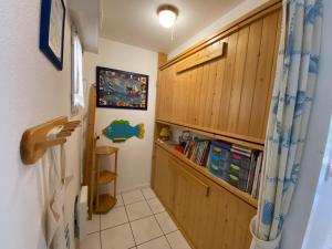 un couloir avec des armoires en bois et une étagère à livres dans l'établissement Oceania, Appartement 2 étoiles à Carnac, à Carnac