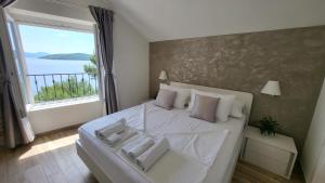 a bedroom with a white bed with a large window at Old Town Sea Front M&M Apartment Korčula in Korčula