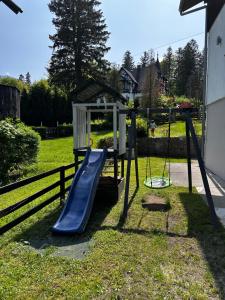 einen Spielplatz mit Rutsche und Schaukel in der Unterkunft Willa Jola in Karpacz