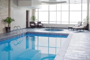 una piscina en una habitación de hotel con mesa y sillas en The Westin Mount Laurel, en Mount Laurel