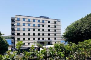 un edificio alto y blanco con árboles delante en Fairfield by Marriott Wakayama Kumano Kodo Susami, en Susami