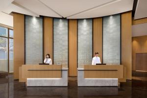 two people sitting at reception desks in a lobby at Fairfield by Marriott Shenshan Special Cooperation Zone in Haifeng
