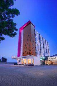 un hotel con un edificio con luz roja en favehotel Simpang Lima - Semarang, en Semarang