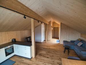 eine Küche und ein Wohnzimmer in einem Holzhaus in der Unterkunft Bergreich Appartement 5 in Schoppernau