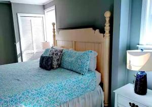um quarto com uma cama com lençóis azuis e uma janela em Cozy Marine Corps Home Near MCRD w/ a Beach Pass em Beaufort