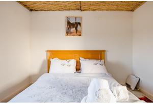 a bedroom with a bed with a horse picture on the wall at Elaaz Horse Farm in Azemmour