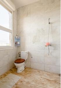 a bathroom with a toilet and a window at Elaaz Horse Farm in Azemmour