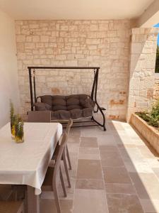 a couch sitting on a patio with a table and chairs at La Racioppola in Ostuni
