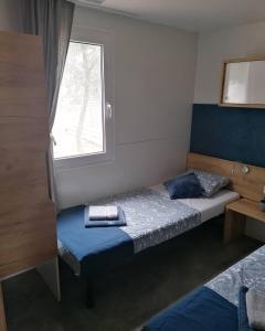 mała sypialnia z łóżkiem i oknem w obiekcie Mobile home Blue Lagoon 785 w Biogradzie na Moru +37 zdjęć