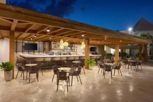 um pátio com mesas e cadeiras e um bar em Courtyard by Marriott Aruba Resort em Palm-Eagle Beach