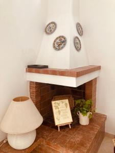 a fireplace with plates and a lamp and a lampost at La Racioppola in Ostuni