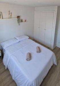 two beds in a bedroom with white walls at Habitación confortable para parejas (1) in Barcelona