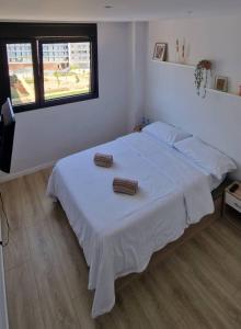 a bedroom with a white bed with two towels on it at Habitación confortable para parejas (1) in Barcelona