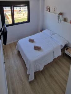 1 dormitorio con 1 cama blanca y 2 toallas en Habitación confortable para parejas (1) en Barcelona