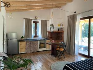 uma sala de estar com uma cozinha, uma mesa e um frigorífico em La Marmotta COUNTRY RELAIS sul lago em Anguillara Sabazia