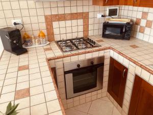 a kitchen with a stove top oven and a microwave at La Racioppola in Ostuni