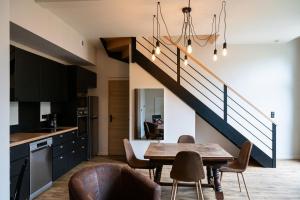 une cuisine et une salle à manger avec une table et un escalier dans l'établissement Château Belle Epoque - Chambres d'Hôtes & Gîtes, à Linxe