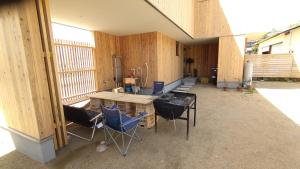 Zimmer mit Tisch und Stühlen in einem Gebäude in der Unterkunft 伯方plus+ in Imabari