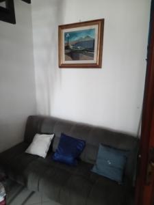 um sofá com almofadas azuis e brancas num quarto em La casa di Eleonora em Nápoles