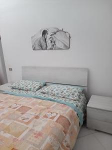 um quarto com uma cama com uma fotografia na parede em La casa di Eleonora em Nápoles