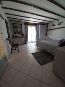 um quarto com uma cama, uma cadeira e uma janela em Las Cafourques Chambre d'Hotes em Ségalas