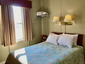 a bedroom with a bed with pillows and a window at Garden Grove Retreat & Lodging near Pictured Rocks, Fayette, Trails in Garden