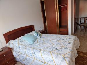 a bedroom with a bed with a blue pillow on it at Chez Gilbert-Alojamento Local in Alqueidão da Serra