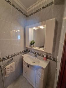 a bathroom with a sink and a mirror at Chez Gilbert-Alojamento Local in Alqueidão da Serra