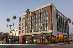 un bâtiment au coin d'une rue bordée de palmiers dans l'établissement The Glenmark, Glendale, a Tribute Portfolio Hotel, à Glendale