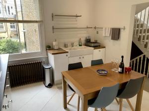 a kitchen with a wooden table and chairs and a sink at Lovely newly refurbished apartment in Battersea in London