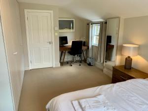 a bedroom with a bed and a desk with a computer at Lovely newly refurbished apartment in Battersea in London