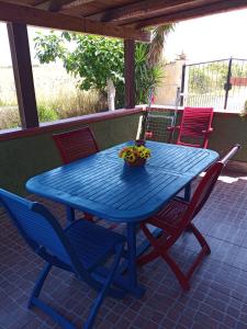 a blue table with chairs and a bowl of fruit at Appartamento Il Salice in Casa Minnina