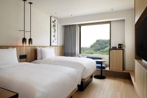 two beds in a hotel room with a window at Fairfield by Marriott Gifu Seiryu Satoyama Park in Minokamo