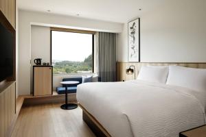 a hotel room with a bed and a window at Fairfield by Marriott Gifu Seiryu Satoyama Park in Minokamo