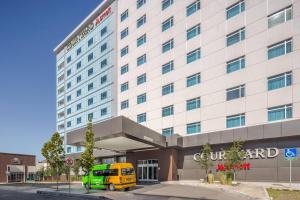 una furgoneta amarilla estacionada frente a un hotel en Courtyard by Marriott Chihuahua en Chihuahua