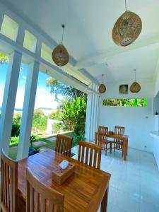 - une salle à manger avec une table et des chaises en bois dans l'établissement The Hill View Lombok, à Kuta Lombok