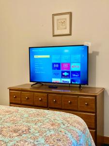 a flat screen tv sitting on a dresser in a bedroom at Garden Grove Retreat & Lodging near Pictured Rocks, Fayette, Trails in Garden