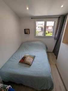 Habitación pequeña con cama y ventana en Studio Meublé très Agréable en Pessac