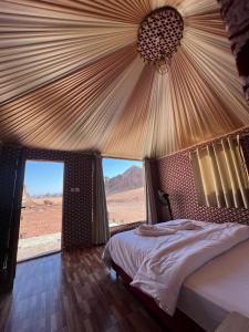 a bedroom with a bed with a view of the desert at The sunset of Wadi Rum in Wadi Rum