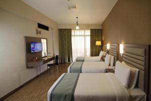ドバイにあるWave International Hotelのベッド2台とテレビがあるホテルの部屋 +35枚の写真