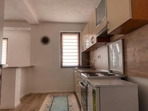 una cucina con armadi bianchi e piano cottura di Dardania Apartments a Pejë