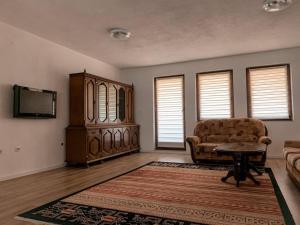 a living room with a couch and a tv at Dardania Apartments in Peje