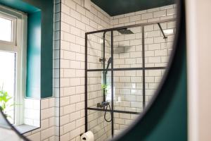 a shower in a bathroom with white tiles at Stunning Townhouse - 7 bedrooms - up to 18 Guests in Cardiff +40 photos