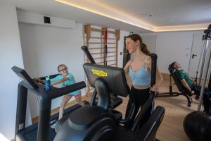 a woman and a child on a treadmill in a gym at Naturhotel Feriengut Darrehof in Serfaus