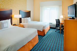 a hotel room with two beds and a flat screen tv at Fairfield Inn & Suites by Marriott San Antonio SeaWorld / Westover Hills in San Antonio