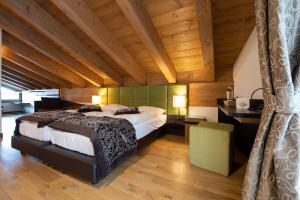 una camera con un grande letto e un soffitto in legno di Hotel Vedig a Santa Caterina Valfurva