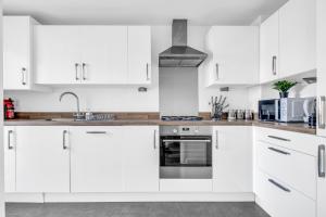 eine weiße Küche mit weißen Schränken und einer Spüle in der Unterkunft City Centre 3 Bedroom House - Family & Business in Birmingham