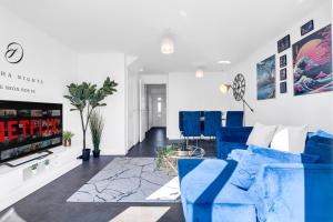 ein Wohnzimmer mit blauen Stühlen und einem Fernseher in der Unterkunft City Centre 3 Bedroom House - Family & Business in Birmingham