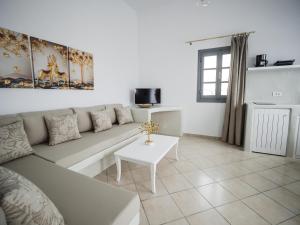 un soggiorno con un divano e un tavolo di Anthemis Suites a Imerovigli